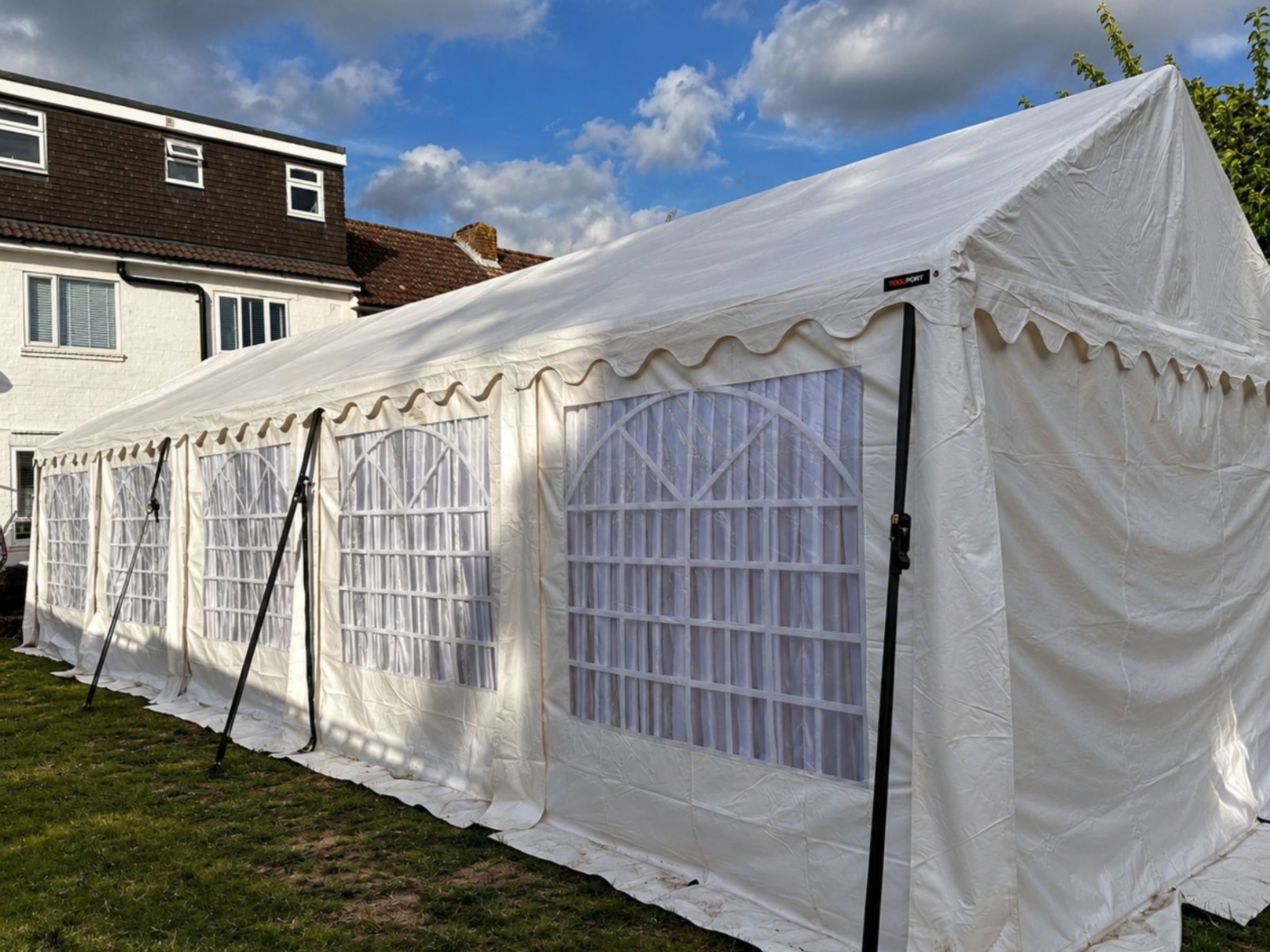 White event marquee assembled on a lawn.