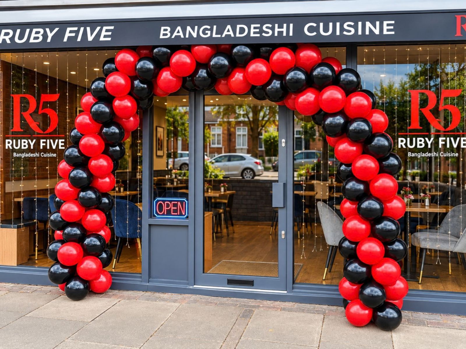 Red and black balloon arch framing a business entrance.