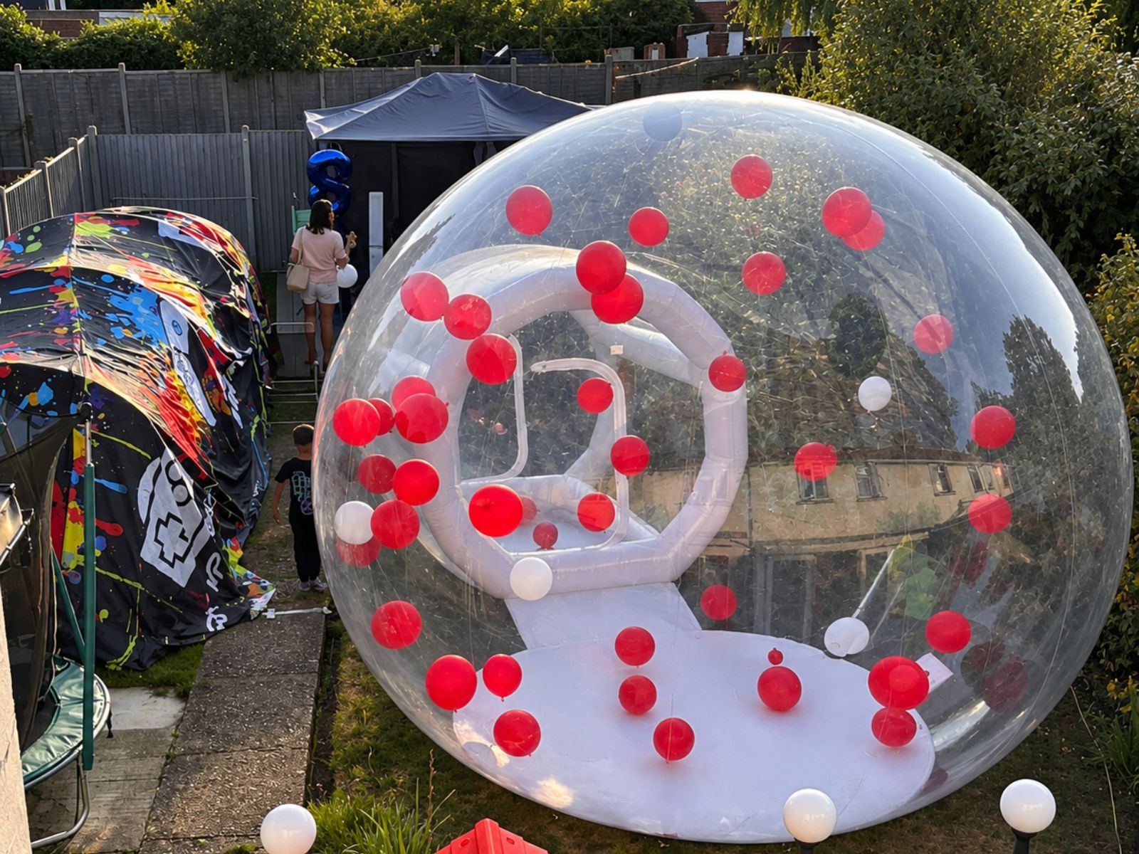 Side view of a transparent bubble house filled with balloons.