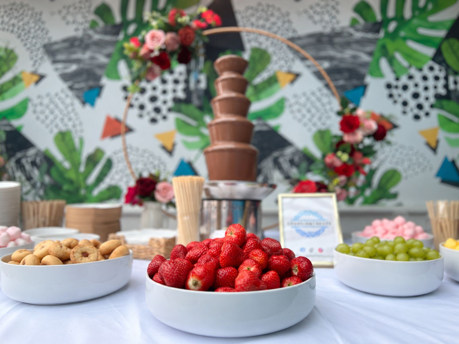 Chocolate fountain arranged with strawberries, fruit and sweet treats.